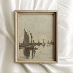 a painting hanging on the side of a wall next to a white bedding sheet