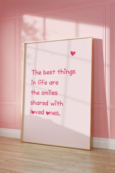 the best things in life are the smiles shared with loved ones quote on pink wall