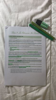 a green pen sitting on top of a piece of paper