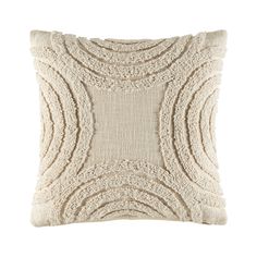 a cream colored pillow with an intricate design on the front and back, made out of yarn