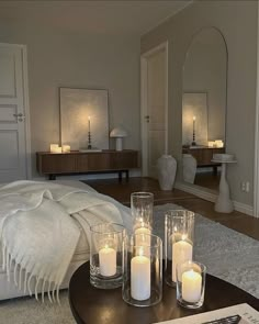 candles sit on a coffee table in front of a mirror