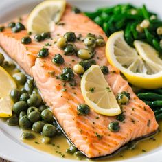 salmon with capers, peas and lemon on a white plate