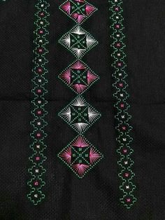 an embroidered black cloth with pink and green designs