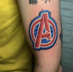 a man with a tattoo on his arm that has the avengers symbol painted on it