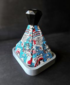 a tie that is on top of a stand in the shape of a pyramid with comic characters all over it