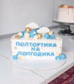 a white cake with blue and gold decorations on it's side sitting on a table