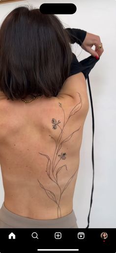 the back of a woman's body with tattoos on her upper and lower back