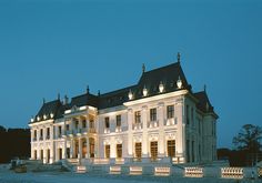 a large white building with lots of windows and lights on it's roof at night