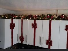 the cabinets are decorated with red bows and lights