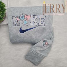 Introducing our Personalized Stitch Disney Nike Embroidered Sweatshirt, the perfect Cute Halloween Gift For Couple! This one-of-a-kind sweatshirt combines the magic of Disney with the comfort and style of Nike, making it a must-have for any Disney lover. Featuring a high-quality embroidered design of Stitch, one of Disney’s most beloved characters, this sweatshirt is truly [...] Disney Characters Stitch, Bluey Bandit, Nike Embroidered Sweatshirt, Disney Nike, Embroidered Shirts, Nike Sweatshirt, Sweatshirt Cute, Holiday Sweatshirt, Disney Lover