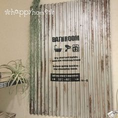 a bathroom sign on the wall next to a potted plant