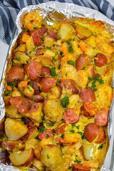 a pan filled with sausage and potatoes covered in cheese