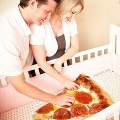 a man and woman are looking at a pepperoni pizza