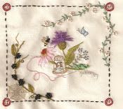 an embroidered square with flowers and butterflies on it's side, in the center