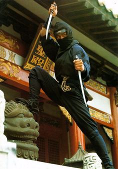 a man in black outfit holding two swords