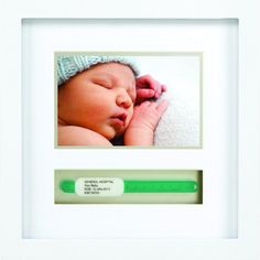 a baby is sleeping in a white frame with a green thermometer next to it