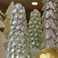 three silver and gold christmas trees are on display