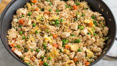 a pan filled with rice and vegetables on top of a table