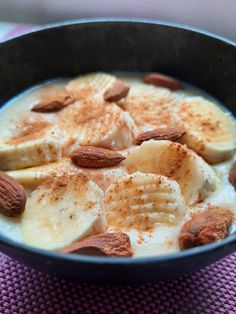 a bowl filled with bananas and almonds on top of a table