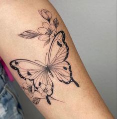 a woman's arm with a black and white butterfly tattoo on the left forearm