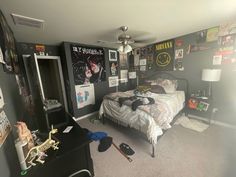 a bedroom with posters on the wall and a bed