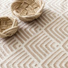 two woven baskets sitting on top of a rug