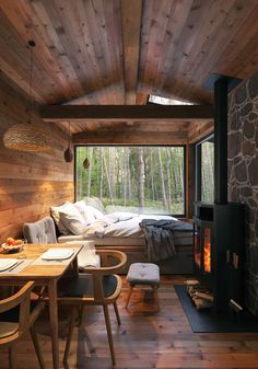 a living room with wood walls and flooring next to a fire place in front of a window