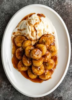 a white plate topped with bananas and ice cream on top of a marble countertop