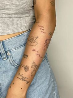 a woman's arm with tattoos on it and words written in cursive writing