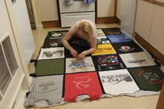 a woman is laying on the floor covered in t - shirts