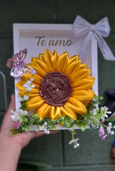 a person holding up a card with a sunflower on it