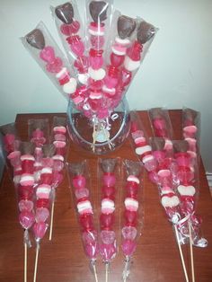 there are many lollipops in the glass vase on the table with candy