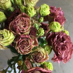 a vase filled with lots of pink and green flowers