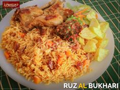 a white plate topped with rice and meat next to potato wedges on a table