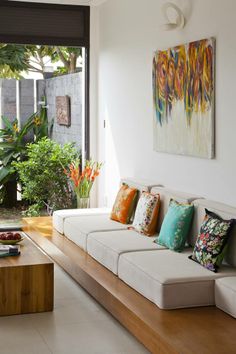 a living room filled with white couches and lots of pillows on top of it