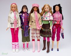 four barbie dolls standing next to each other