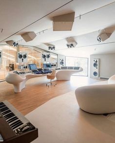 a large room with lots of white furniture and speakers on the walls, along with an array of sound equipment