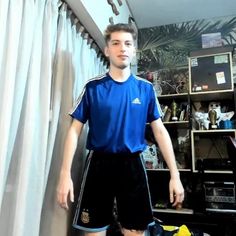 a young man standing in front of a book shelf