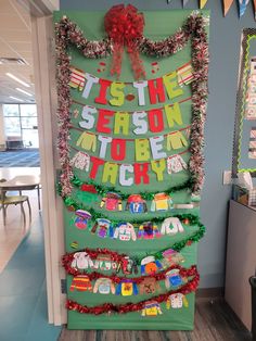 a classroom door decorated with christmas decorations and writing on the front, along with ribbons