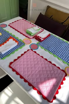 the table is covered with pink and blue placemats, green napkins, and cake