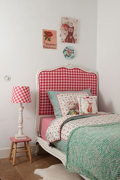 a bedroom with a bed, nightstands and pictures on the wall above it is decorated in red and white