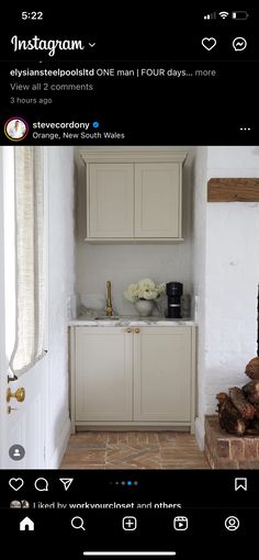 a kitchen with white cabinets and wood logs