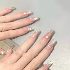 someone has painted their nails pink and white with stars on the tip of each finger