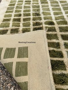 two green and white rugs sitting on top of a gravel ground next to each other