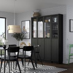 a dining room with black chairs and a white rug