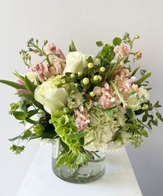 a vase filled with lots of white and pink flowers