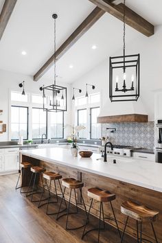 a large kitchen island with four stools in front of it and an open floor plan