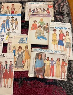 six vintage sewing patterns from the 1970's and 70's are laid out on a rug