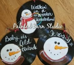 three black and white plates with snowmen painted on them