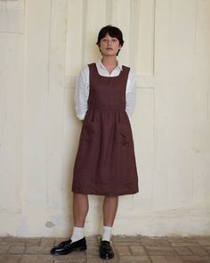 Our Pinafore dress is designed to be a versatile member of your closet, with front pockets and buttoning shoulder straps, wear it over dresses, sweaters, or while you are creating, making, gardening, baking. Crafted to a high standard in California from sustainably grown, medium weight European linen. DETAILS Dress Features:- A deep neckline with buttoning shoulder straps- An adjustable waist tie (the back of the dress has two small belt loops and a removable tie)- Front pockets Fabric: 100% pre Wool Pinafore Dress, Vintage Sleeveless Pinafore Dress With Pockets, Vintage Pinafore Dress, Brown Sleeveless Cotton Pinafore Dress, Fitted A-line Pinafore Dress, Casual A-line Fitted Pinafore Dress, Wool Leg Warmers, Ginger Dress, British Uniforms